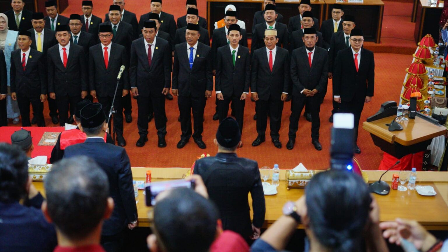 Dalam rangka memperkuat struktur pemerintahan daerah dan meneguhkan komitmen terhadap pelayanan publik, Rapat Paripurna Pengucapan Sumpah/Janji Anggota DPRD Kabupaten Bone menjadi momen penting bagi masyarakat dan pemerintah daerah. Acara ini tidak hanya menjadi seremonial rutin, tetapi juga simbol dari harapan dan tanggung jawab yang diemban oleh anggota DPRD yang baru dilantik. Mewakili Penjabat Bupati Bone, Sekretaris Daerah Kabupaten Bone, Drs. H. Andi Islamuddin, M.H., hadir dalam acara tersebut untuk memberikan dukungan dan memastikan pelaksanaan tugas pemerintahan berjalan dengan baik. Melalui artikel ini, kita akan mendalami rangkaian acara, makna dari pengucapan sumpah, serta harapan yang diusung oleh para wakil rakyat dalam menjalankan amanah mereka. 1. Rangkaian Acara Rapat Paripurna Rapat Paripurna Pengucapan Sumpah/Janji Anggota DPRD Kabupaten Bone diselenggarakan dengan penuh khidmat. Acara ini dimulai dengan pembukaan oleh Ketua DPRD Kabupaten Bone, yang menjelaskan tujuan dan pentingnya kegiatan tersebut. Dalam sambutannya, Ketua DPRD menekankan bahwa anggota DPRD yang baru dilantik harus siap untuk menjalankan fungsi dan tugasnya sebagai wakil rakyat. Acara dilanjutkan dengan pembacaan Surat Keputusan Gubernur mengenai pengangkatan anggota DPRD terpilih, yang merupakan hasil dari pemilihan umum yang berlangsung beberapa waktu lalu. Setelah pembacaan tersebut, dilanjutkan dengan pengucapan sumpah/janji oleh anggota DPRD yang baru. Pengucapan sumpah ini diambil di hadapan Tuhan dan disaksikan oleh masyarakat, sehingga memiliki bobot moral dan etika yang tinggi. Proses ini diharapkan dapat menumbuhkan rasa tanggung jawab dan kesadaran akan tugas yang diemban oleh para wakil rakyat. Selama acara, Sekretaris Daerah Kab. Bone, Drs. H. Andi Islamuddin, M.H., memberikan sambutan yang penuh makna, menekankan pentingnya kolaborasi antara eksekutif dan legislatif dalam mencapai tujuan pembangunan daerah. 2. Makna Pengucapan Sumpah/Janji Anggota DPRD Pengucapan sumpah/janji oleh anggota DPRD adalah salah satu momen paling signifikan dalam rangkaian acara Rapat Paripurna. Ini bukan sekadar formalitas, melainkan sebuah ikatan moral yang mengharuskan anggota DPRD untuk bertanggung jawab atas tugas dan fungsi mereka sebagai wakil rakyat. Pengucapan ini mengandung komitmen untuk menjaga integritas, tujuan, dan aspirasi masyarakat. Dengan mengucapkan sumpah, anggota DPRD diharapkan mampu mengedepankan kepentingan publik di atas kepentingan pribadi atau kelompok. Pengucapan sumpah/janji ini juga menjadi simbol dari demokrasi yang sehat. Anggota DPRD yang baru dilantik diharapkan untuk bersikap transparan dan akuntabel dalam setiap langkah kebijakan yang diambil. Dengan adanya pengawasan dari masyarakat, diharapkan setiap keputusan yang diambil oleh anggota DPRD akan lebih mempertimbangkan kepentingan dan kebutuhan rakyat. Hal ini menjadi penting agar kepercayaan masyarakat terhadap lembaga legislatif tetap terjaga. Lebih dari itu, pengucapan sumpah ini juga menjadi momentum refleksi bagi anggota DPRD untuk senantiasa mengingat kembali visi dan misi yang diusung selama kampanye. Masyarakat telah mempercayakan suara mereka, dan anggota DPRD harus berkomitmen untuk tidak mengecewakan harapan tersebut. Dalam konteks ini, Sekretaris Daerah Kab. Bone, Drs. H. Andi Islamuddin, M.H., memberikan penekanan pada pentingnya komunikasi yang baik antara anggota DPRD dengan masyarakat, guna memastikan bahwa aspirasi masyarakat dapat terakomodasi dalam setiap kebijakan yang diambil. 3. Harapan dari Sekretaris Daerah Kab. Bone Sebagai wakil dari Penjabat Bupati Bone, Drs. H. Andi Islamuddin, M.H., menyampaikan harapan yang tinggi terhadap kinerja anggota DPRD yang baru dilantik. Dalam sambutannya, beliau mengungkapkan bahwa kerjasama antara eksekutif dan legislatif sangatlah penting dalam menciptakan sinergi yang positif bagi pembangunan daerah. Sekretaris Daerah berharap agar anggota DPRD dapat menjalankan fungsi legislasi, pengawasan, dan anggaran dengan baik. Drs. H. Andi Islamuddin juga menekankan perlunya inovasi dalam menghadapi berbagai tantangan yang ada. Dalam era digital saat ini, anggota DPRD dituntut untuk lebih kreatif dalam menciptakan kebijakan yang responsif terhadap perubahan kebutuhan masyarakat. Beliau berharap agar anggota DPRD dapat memanfaatkan teknologi informasi untuk meningkatkan transparansi dan akuntabilitas dalam setiap proses pengambilan keputusan. Selain itu, harapan lain yang disampaikan adalah untuk meningkatkan partisipasi masyarakat dalam proses legislasi. Anggota DPRD diharapkan untuk lebih aktif dalam menjalin komunikasi dengan konstituen mereka, agar setiap keputusan yang diambil benar-benar mencerminkan aspirasi masyarakat. Sekretaris Daerah juga mengingatkan pentingnya menjaga etika dan integritas dalam menjalankan tugas, sehingga kepercayaan masyarakat terhadap lembaga DPRD tetap terjaga. 4. Tantangan dan Peluang ke Depan Dalam menjalankan tugasnya, anggota DPRD akan menghadapi berbagai tantangan. Salah satu tantangan terbesar adalah bagaimana menjawab harapan masyarakat akan pelayanan publik yang lebih baik. Masyarakat saat ini semakin kritis dan memiliki akses informasi yang lebih luas, sehingga anggota DPRD dituntut untuk lebih responsif dan proaktif dalam menyikapi permasalahan yang ada. Namun, di balik tantangan tersebut terdapat peluang yang dapat dimanfaatkan. Dengan adanya dukungan dari pemerintah daerah, anggota DPRD dapat bekerja lebih efektif dalam merumuskan kebijakan yang berpihak kepada masyarakat. Selain itu, peluang untuk meningkatkan kapasitas SDM melalui pelatihan dan pendidikan juga sangat terbuka lebar. Anggota DPRD yang memiliki pengetahuan dan keterampilan yang baik akan lebih mampu dalam menjalankan tugas dan fungsinya. Sekretaris Daerah Kab. Bone, Drs. H. Andi Islamuddin, M.H., menutup harapan ini dengan menyerukan kepada seluruh anggota DPRD agar dapat bekerja sama secara optimal, baik antar anggota DPRD itu sendiri maupun dengan eksekutif. Sinergi yang baik akan berkontribusi positif bagi kemajuan Kabupaten Bone, sehingga segala tantangan yang ada dapat dihadapi dengan lebih baik.